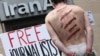 FILE - Reporters Without Borders activists take part in a protest in front of an Iran Air agency in Paris, on July 10, 2012.
