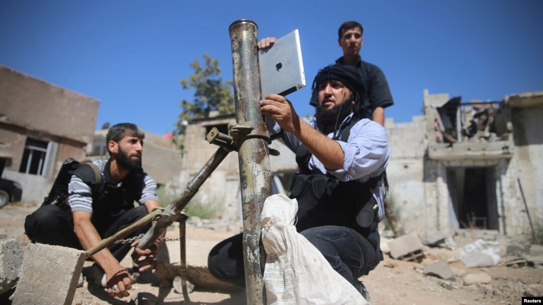 ARCHIVO - Un miembro de la Brigada 'Ansar Dimachk', parte de la Brigada 'Asood Allah' que opera bajo el Ejército Libre Sirio, usa un iPad durante los preparativos para disparar un mortero casero en uno de los frentes de batalla en Jobar, Damasco, el 15 de septiembre de 2013. 