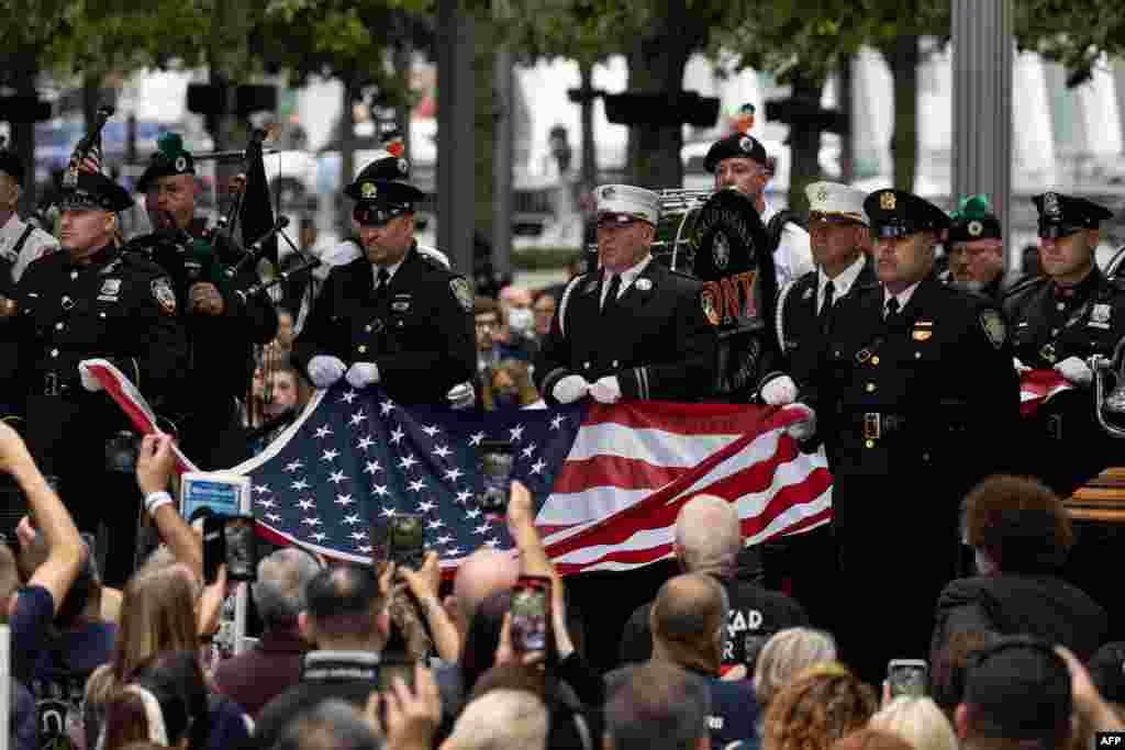 Members of New York Fire Department raise a U.S. flag at the 9/11 Memorial in New York City, Sept. 11, 2022