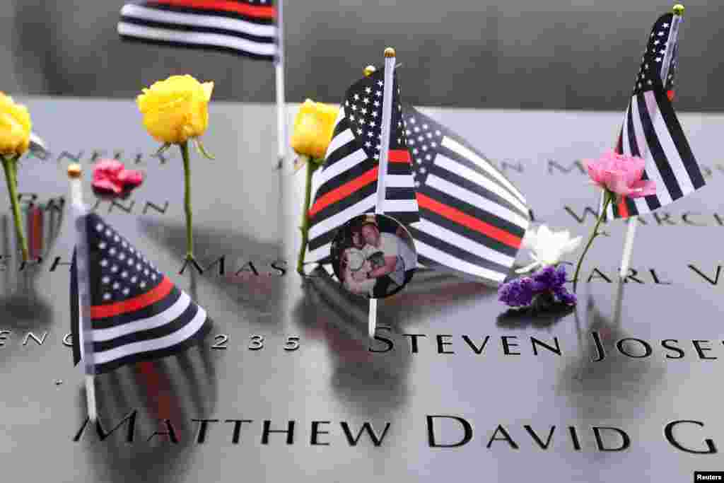 Flags and flowers are placed at the 9/11 Memorial and Museum during a ceremony marking the 21st anniversary of the September 11, 2001 attacks on the World Trade Center, in the Manhattan borough of New York City, Sept. 11, 2022.