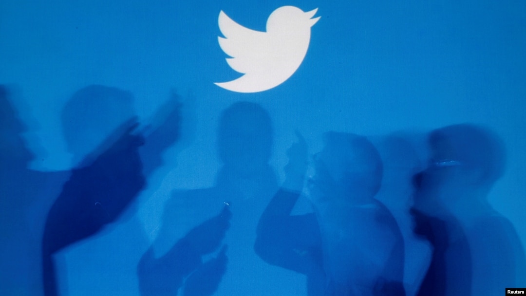 Archivo - Las sombras de las personas que sostienen teléfonos móviles se proyectan sobre un fondo con el logotipo de Twitter en esta imagen ilustrativa tomada en Varsovia el 27 de septiembre de 2013.