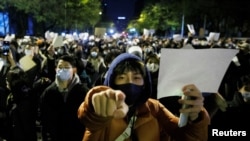 资料照片：2022年11月27日，北京的年轻人手举白纸上街示威，抗议新冠清零封控政策。（路透社照片）