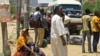 People wait for a bus to flee from southern Khartoum, Sudan, April 18, 2023, as fighting between the army and paramilitary forces led by rival generals rages for a fourth day.