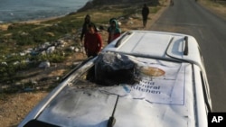 Palestinianos inspeccionam um veículo com o logótipo da World Central Kitchen destruído por um ataque aéreo israelita em Deir al Balah, na Faixa de Gaza, a 2 de abril de 2024.