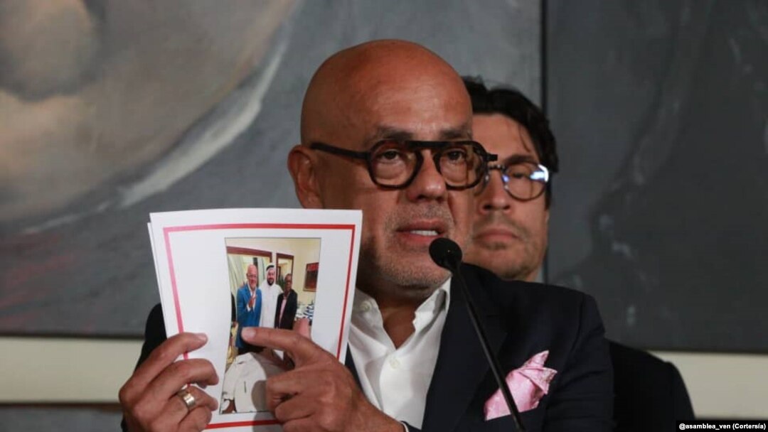 Jorge Rodríguez, presidente del Parlamento de mayoría oficialista de Venezuela muestra una fotografía en la que se le ve junto a Brian Nichols durante un proceso directo de negociaciones. 