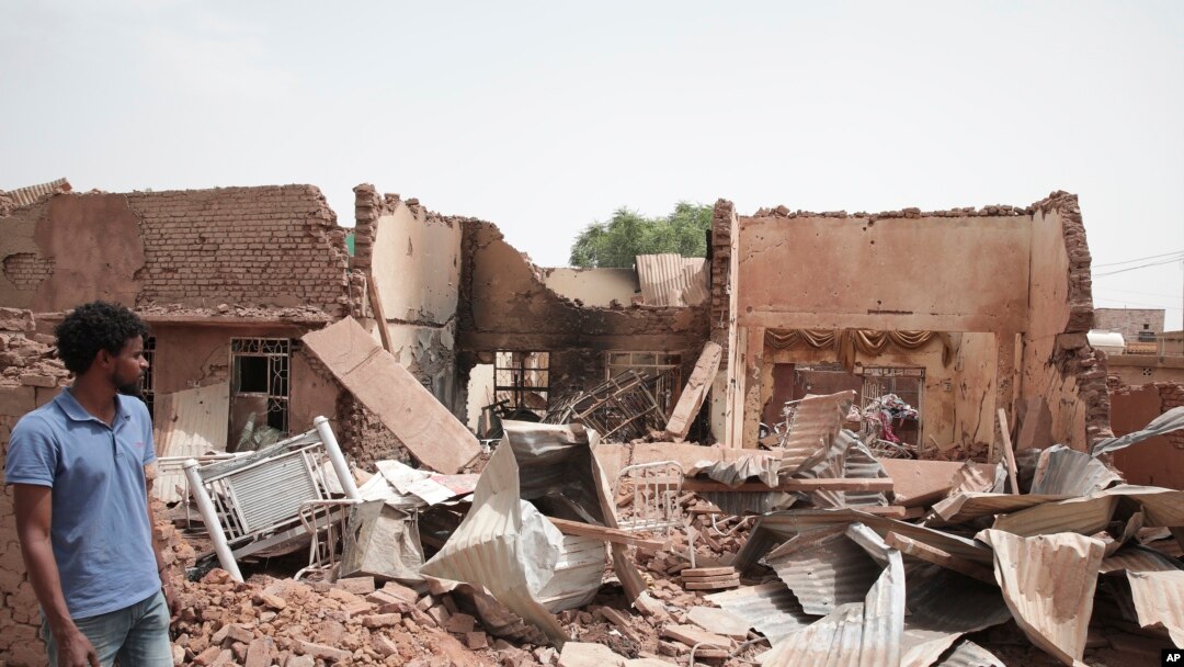 A man walks by a house hit in recent fighting in Khartoum, Sudan, April 25, 2023.