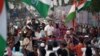 Rahul Gandhi, a senior leader of India's main opposition Congress Party, center, and his sister and party leader Priyanka Gandhi Vadra, center-right, are greeted as they drive through Mumbai, March 16, 2024, during their "Unite India Justice March."