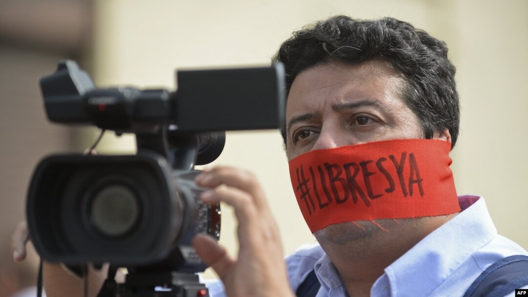 ARCHIVO - Un camarógrafo protesta el 27 de mayo de 2016 en Cali, Colombia, pidiendo la liberación de Diego D'Pablos y del camarógrafo Carlos Melo, ambos periodistas de Noticias RCN. 