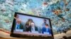 U.N. High Commissioner for Human Rights Volker Turk, center, is seen on a TV monitor speaking during a session of the 52nd U.N. Human Rights Council, in Geneva, on March 6, 2023. 