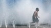 FILE - A child plays in a fountain to cool off in downtown Portland, Oregon, May 12, 2023.