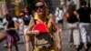 FILE - A woman fans herself in Madrid, Spain, July 10, 2023. 
