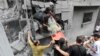 Palestinians carry an injured man out of the destruction following Israeli airstrikes on Gaza City, Oct. 27, 2023.