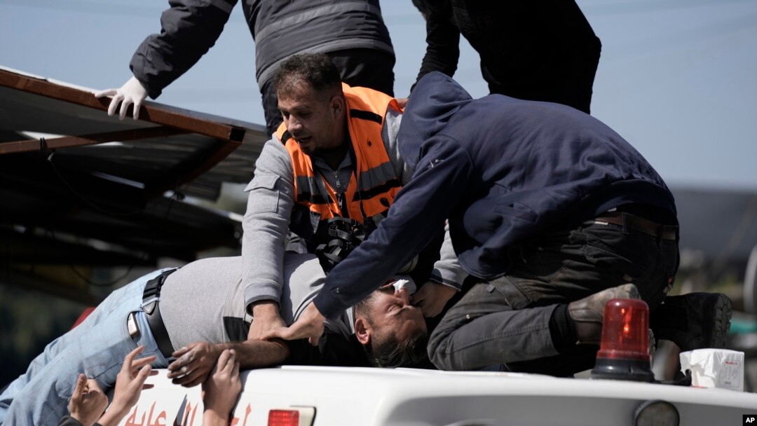 An injured Palestinian is lifted onto an ambulance during clashes with Israeli forces in the West Bank city of Nablus, Wednesday, Feb. 22, 2023. 