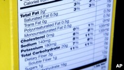 FILE - A nutrition facts label is seen on the side of a cereal box in Washington, D.C, Jan. 23, 2014. A survey of WHO’s 194 member states shows “the world is off track to achieve its global target of reducing sodium intake by 30% by 2025.” 