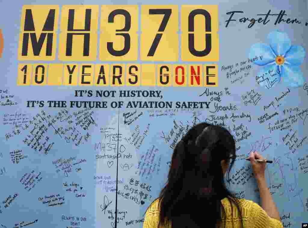 A woman writes a message on the message board during the tenth annual remembrance event at a shopping mall, in Subang Jaya, on the outskirts of Kuala Lumpur, Malaysia.&nbsp;Ten years ago, a Malaysia Airlines Flight 370, had disappeared March 8, 2014 while en route from Kuala Lumpur to Beijing with over 200 people on board.&nbsp;