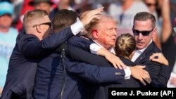 ARCHIVO - Agentes del Servicio Secreto se llevan al candidato presidencial republicano Donald Trump del escenario tras recibir un disparo durante un acto de campaña, el 13 de julio de 2024, en Butler, Pensilvania