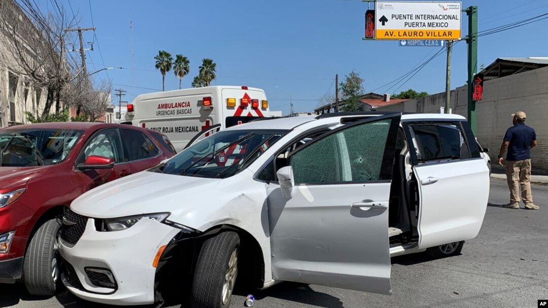 Un miembro de las fuerzas de seguridad mexicanas junto a una minivan blanca con placas de Carolina del Norte y varios agujeros de bala, donde hombres armados secuestraron a cuatro ciudadanos estadounidenses que cruzaron a México desde Texas, el viernes 3 de marzo de 2023.