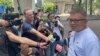 Hong Kong Journalists Association's Chairman Ronson Chan, right, speaks to reporters outside a court building in Hong Kong, Sept. 25, 2023. 