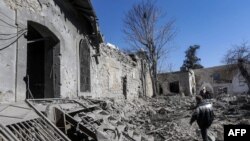 Um homem inspecciona os danos na sequência de um ataque aéreo israelita que atingiu a Cidadela Medieval de Damasco a 19 de Fevereiro de 2023.