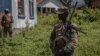 O soldado M23 guarda a área durante a reunião entre oficiais da Força Regional da África Oriental (EACRF) e rebeldes M23 durante a cerimónia de entrega no campo de Rumangabo, no leste da República Democrática do Congo, a 6 de Janeiro de 2023.