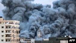 Uma nuvem de fumo ergue-se acima dos edifícios na Cidade de Gaza, a 7 de outubro de 2023, durante um ataque aéreo israelita que atingiu o edifício Palestine Tower. 