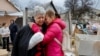 Svetlana Boiko, que foi ferida num ataque recente, é consolada por sua conhecida Yulia Kryukova, perto da sua casa destruída, em Donetsk, Ucrânia, a 12 de Março de 2023.