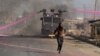 A supporter of Kenya's opposition leader Raila Odinga runs in front of a water canon during a nationwide protest over cost of living and President William Ruto's government in Nairobi, Kenya, March 30, 2023