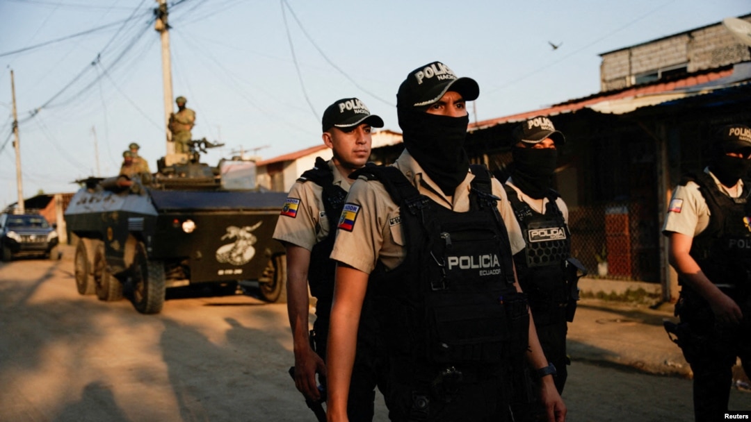 ARCHIVO - Policía caminan delante de un vehículo militar blindado durante una operación conjunta militar y policial conjunta en Guayaquil, Ecuador, el 26 de marzo de 2024, esta ciudad se ha convertido en el epicentro de combates contra estructuras del crimen organizado.