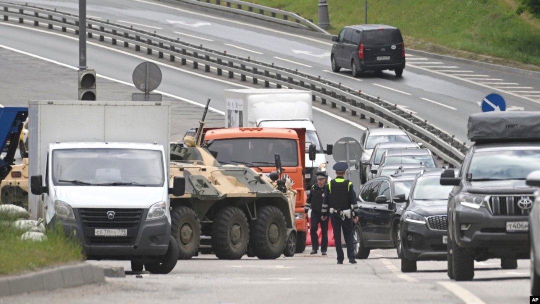 An APC and road police officers stand on the highway at the entrance to Moscow, Russia, June 24, 2023. 