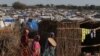 FILE - Sudanese women, who fled the conflict in Geneina in Sudan's Darfur region, walk beside makeshift shelters in Adre, Chad, Aug. 5, 2023. 