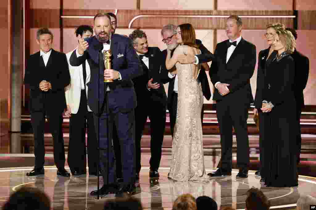 This image released by CBS shows filmmaker Yorgos Lanthimos, foreground, with the cast as he accepts the award for best motion picture - musical or comedy for "Poor Things" during the 81st Annual Golden Globe Awards in Beverly Hills, Calif., on Sunday, Jan. 7, 2024. 