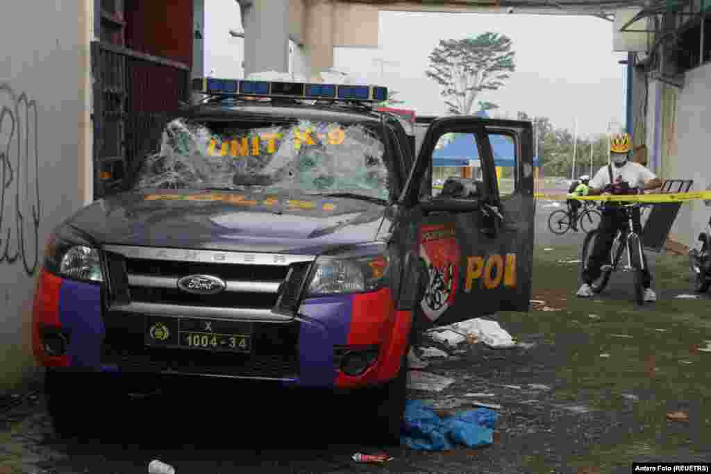 ဖျက်ဆီးခံထားရတဲ့ ရဲကားတစီးကို ကွင်းအပေါက်ဝမှာ ဘောလုံးပွဲရုန်းရင်းဆန်ခတ်မှုတွေအပြီး တွေ့ရပါတယ်။