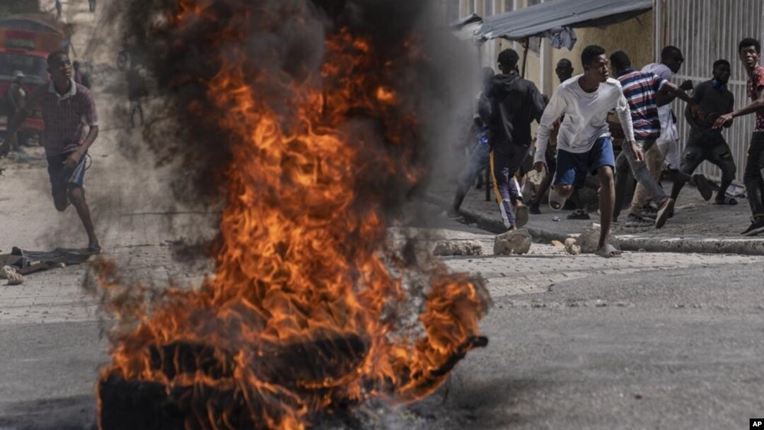 Manifestantes arrojan piedras a la policía durante una protesta por la muerte del periodista Romelo Vilsaint, el 30 de octubre de 2022, en Puerto Príncipe.