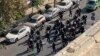 FILE - This image from a video taken by an individual not employed by the AP and obtained outside Iran shows police arriving to disperse a protest to mark 40 days since the death of Mahsa Amini, in Tehran, Oct. 26, 2022.