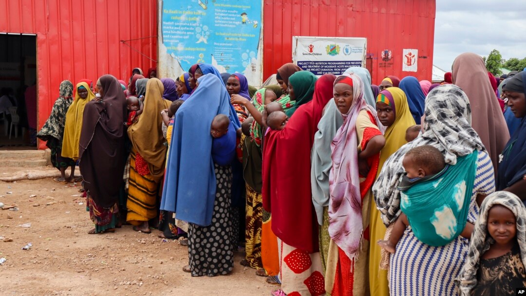 FILE - Somali women and children who left rural areas due to drought receive nutritional assistance at a camp for the internally displaced, on the outskirts of Baidoa, Somalia, Oct. 12, 2022.