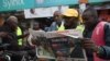 Motorcycle riders read The Standard, a local daily newspaper, with a headline reporting the election of Kenya's 5th President elect William Ruto, in Eldoret, Aug. 16, 2022. 