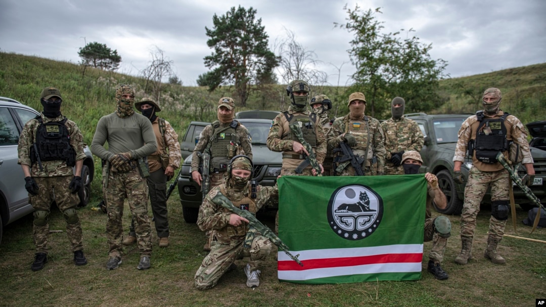 Volunteer soldiers pose with a flag of the Chechen Republic of Ichkeria after training near Kyiv, Ukraine, Aug. 27, 2022. Volunteers have signed up to fight on both sides of the conflict.
