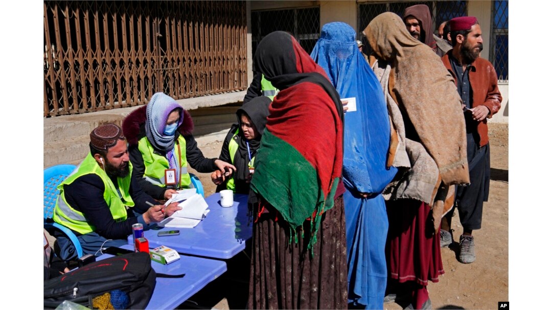 FILE - Afghans register to receive food supplies during a distribution of humanitarian aid for families in need, in Kabul, Afghanistan, Feb. 16, 2022.