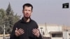 FILE - In this still image taken from an undated video published on the Internet by the Islamic State group militants, captive British journalist John Cantlie speaks into a camera in what he identifies as the embattled Syrian town of Kobani. 