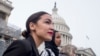 FILE - Rep. Alexandria Ocasio-Cortez, left, and D-N.Y., Rep. Ilhan Omar, D-Minn., center, walk down the House steps to take a group photograph of the House Democratic women members of the 116th Congress on the East Front Capitol Plaza on Capitol Hill.