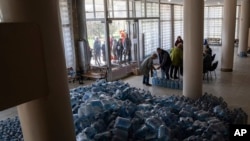 FILE - Local residents receive drinking water at a distribution centre in Toretsk, eastern Ukraine, April 25, 2022. 
