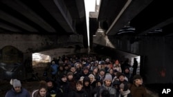 abanya-Ukraine barundanye munsi y'ikiraro casambuwe barondera kujabuka uruzi Irpin mu micungararo wa Kiev, Ukraine, kw'itariki ya 8/3/2022
