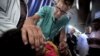 FILE - A Norwegian doctor treats a Palestinian girl in a hospital in Gaza City, where the power goes off repeatedly as aging hospital generators buckle under daily rolling blackouts Gaza residents have lived with for years. 
