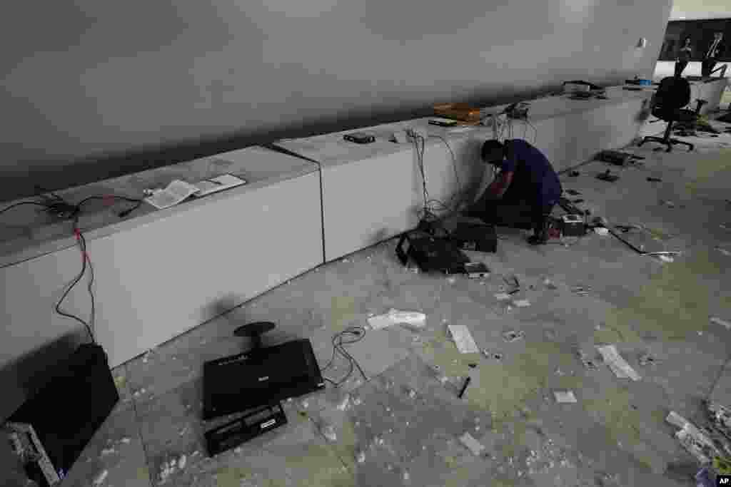Un trabajador inspecciona las computadoras destruidas en la entrada principal del Palacio Planalto, la oficina del presidente, el día después de que asaltaran el lugar.