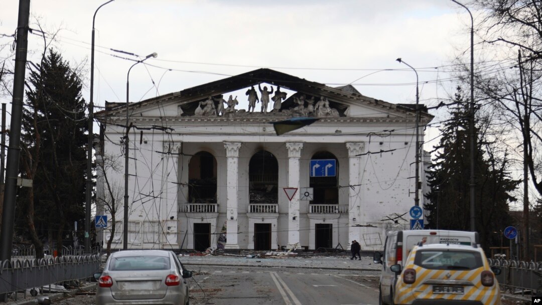 Foto Achiv: Moun mache bo kote teyat rejyonal akademik Donetsk la ki sitye nan Mariupol, Ikren. 