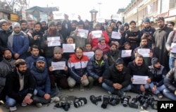 FILE - Kashmiri journalists hold placards during a march protesting media restrictions, in Srinagar, Jan. 26, 2019.