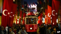 A tram rides past the spot of Sunday's explosion on Istanbul's popular pedestrian Istiklal Avenue in Istanbul, Turkey, Nov. 14, 2022.