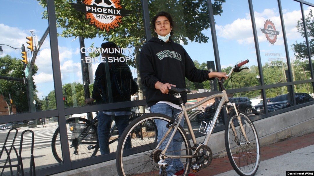 Anthony Jimenez-Galindo with his finished bike outside the Phoenix Bikes store. (Dan Novak/VOA)