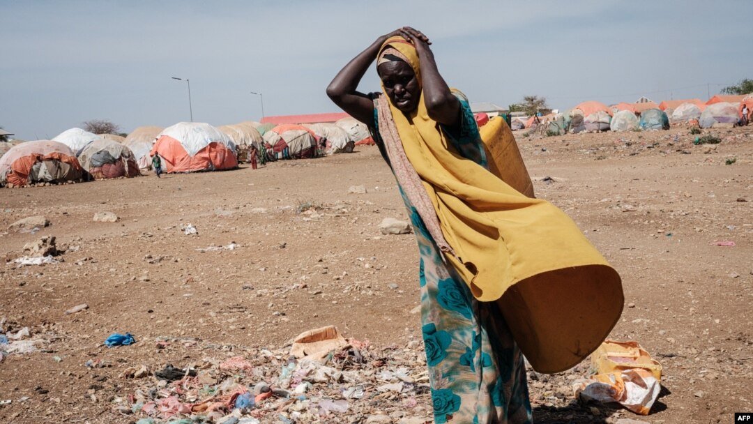FILE - A woman carries a water container at a camp for internally displaced persons (IDPs) in Baidoa, Somalia, Feb. 13, 2022.
