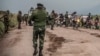 People walk along a road near Kibumba, north of Goma, Democratic Republic of Congo, as they flee fighting between Congolese forces and M23 rebels in North Kivu, May 24, 2022. 